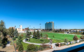 A view of a green field with a building in the background.